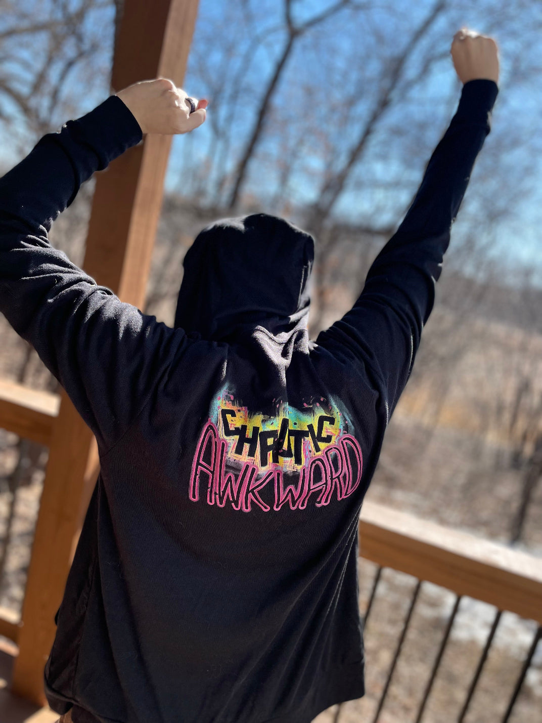 Model wearing a Hoodie that says "Chaotic Awkward" on the back.