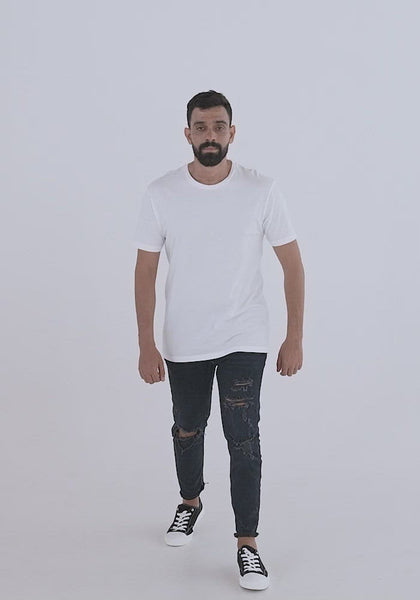 Video of man of medium build with dark hair and beard wearing ripped jeans showing the fit of the masc fit shirt. crew neckline style, sleeves hem long but still above the elbow, tapered fit to give tailored look. 